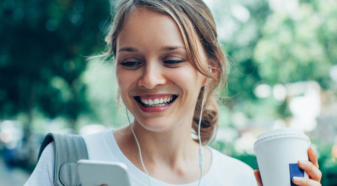 Junge Frau spielt via Smartphone Podcast ab.