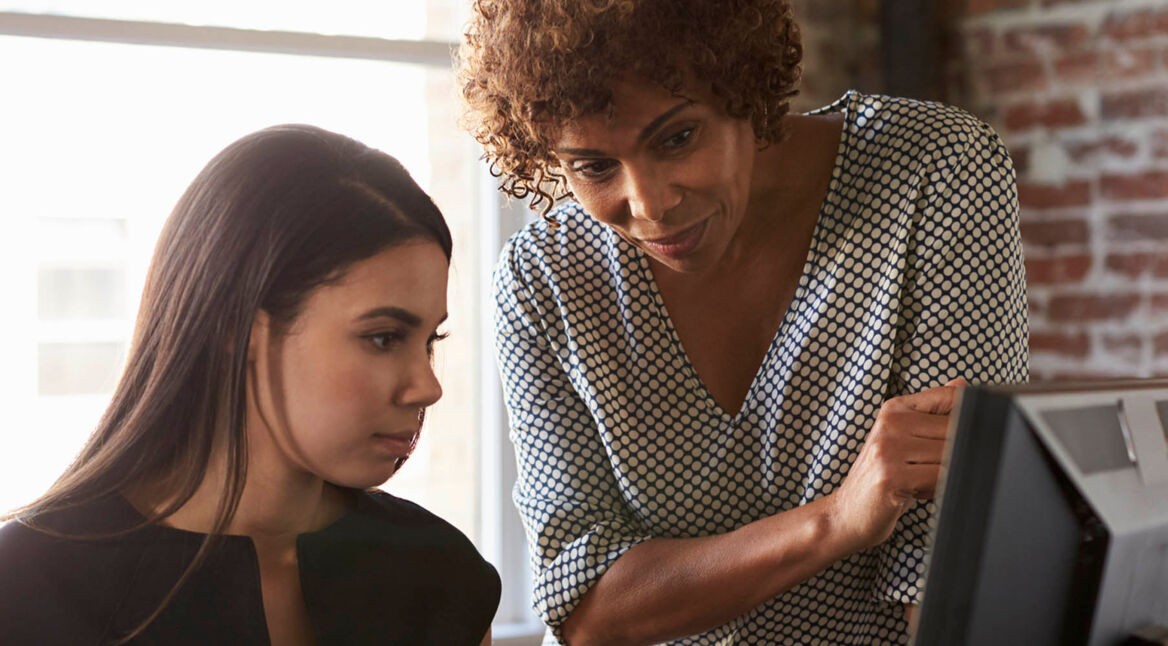 Kolleginnen lösen die Probleme mit Microsoft Edge am Computer.