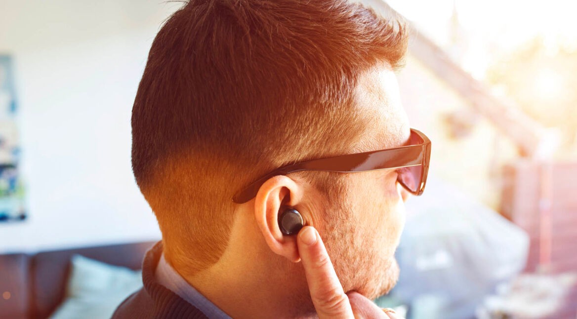 Mann trägt zum Musik hören die kabellosen Galaxy Buds.