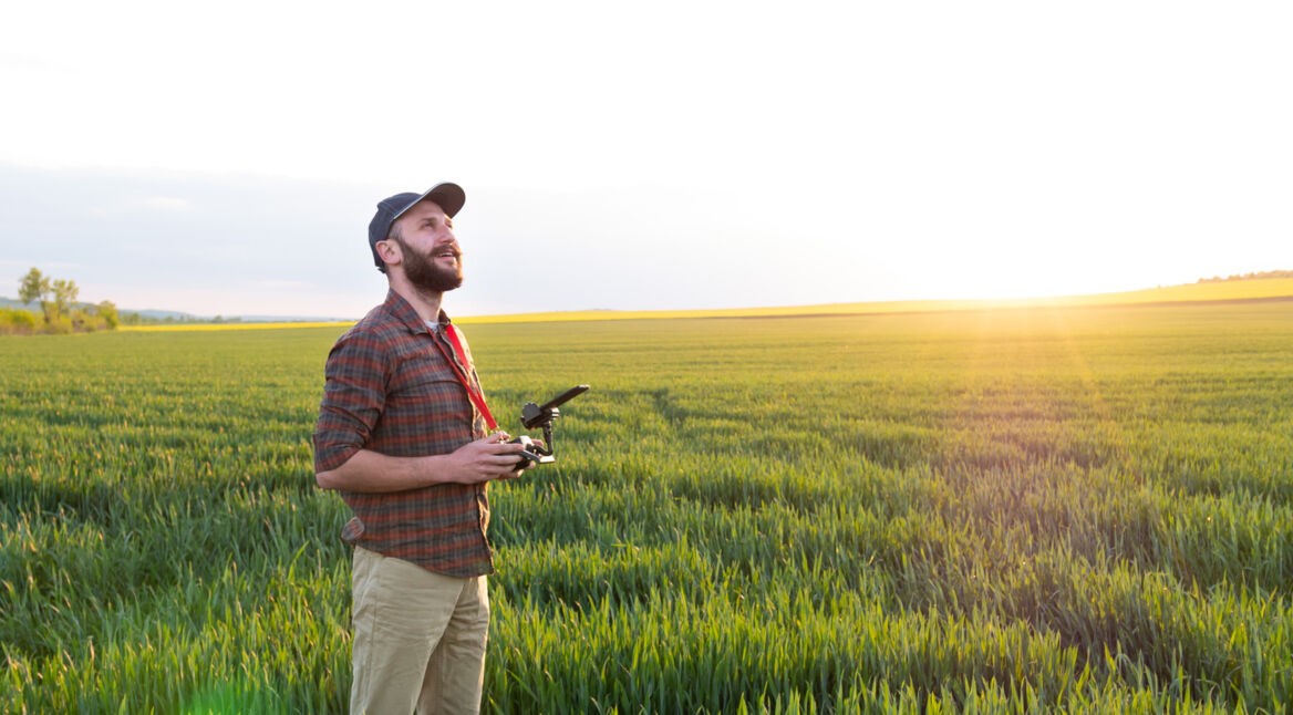 Drohnenpilot fliegt Drohne im Grünen