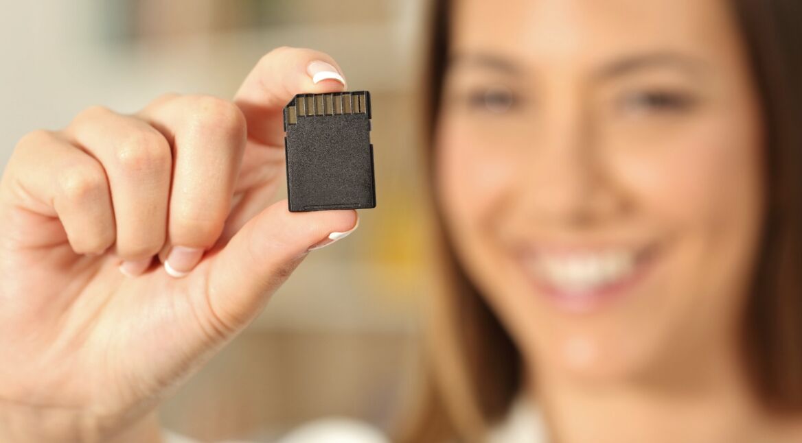 Frau hält SD-Karte in die Kamera