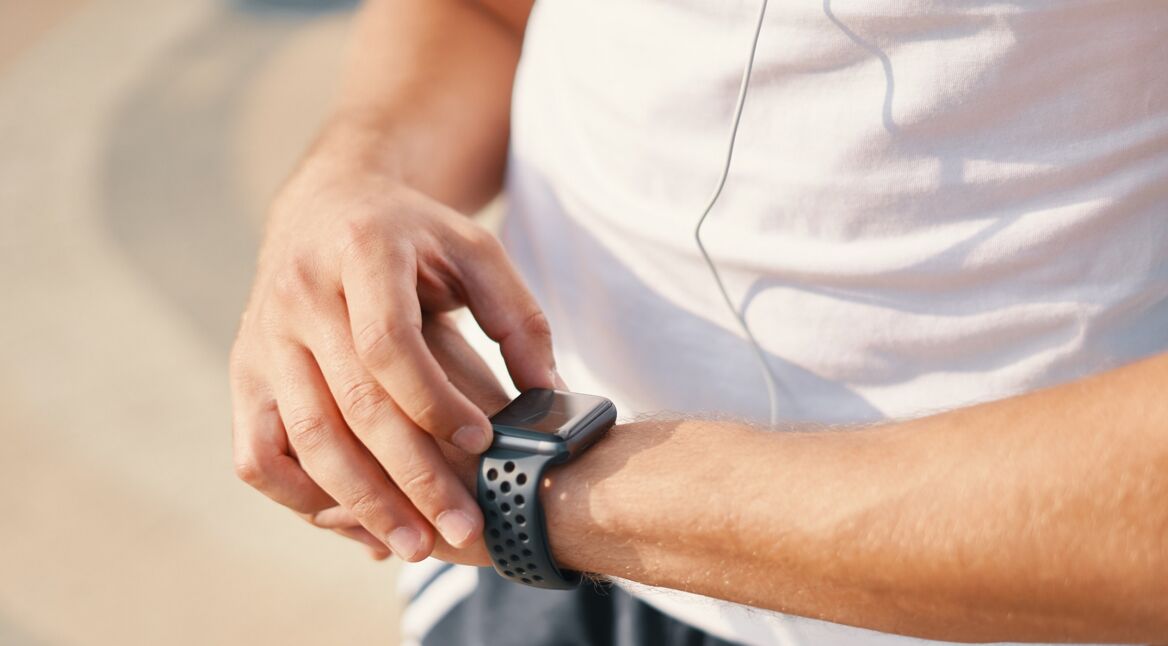 Junger Mann stellt auf seiner Apple Watch die Helligkeit ein