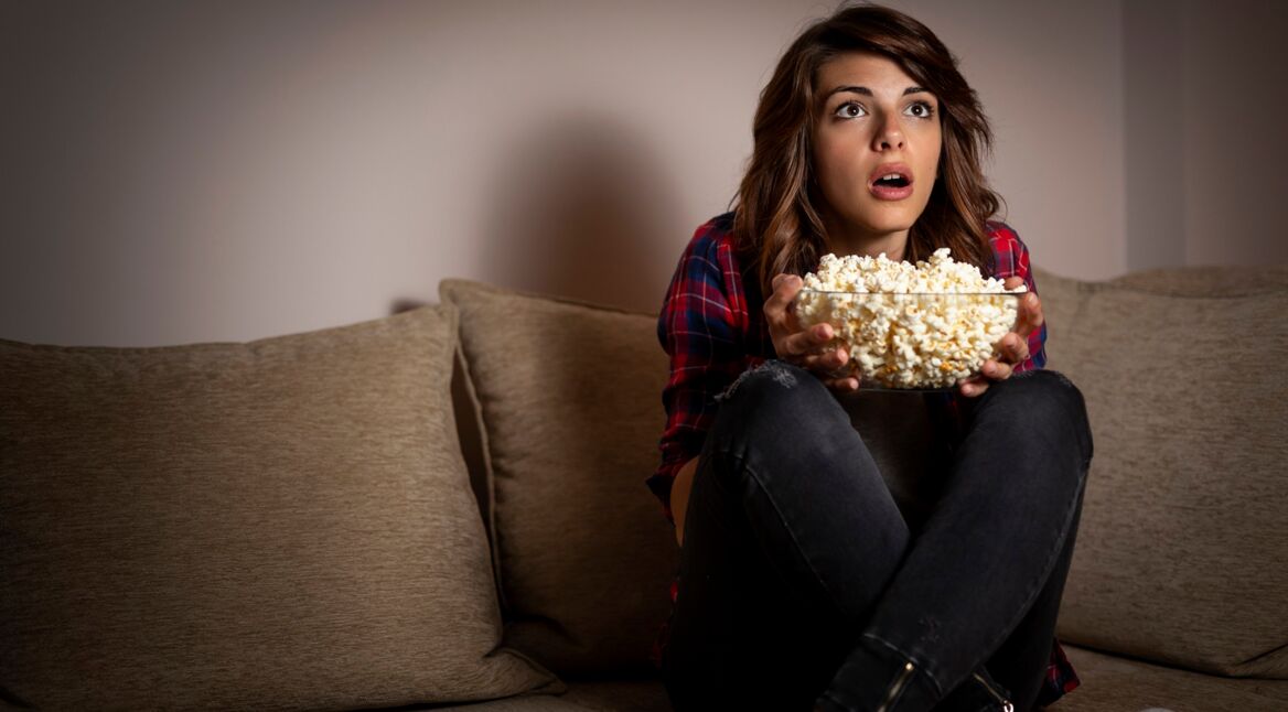 Eine junge Frau schaut eine Folge Black Mirror