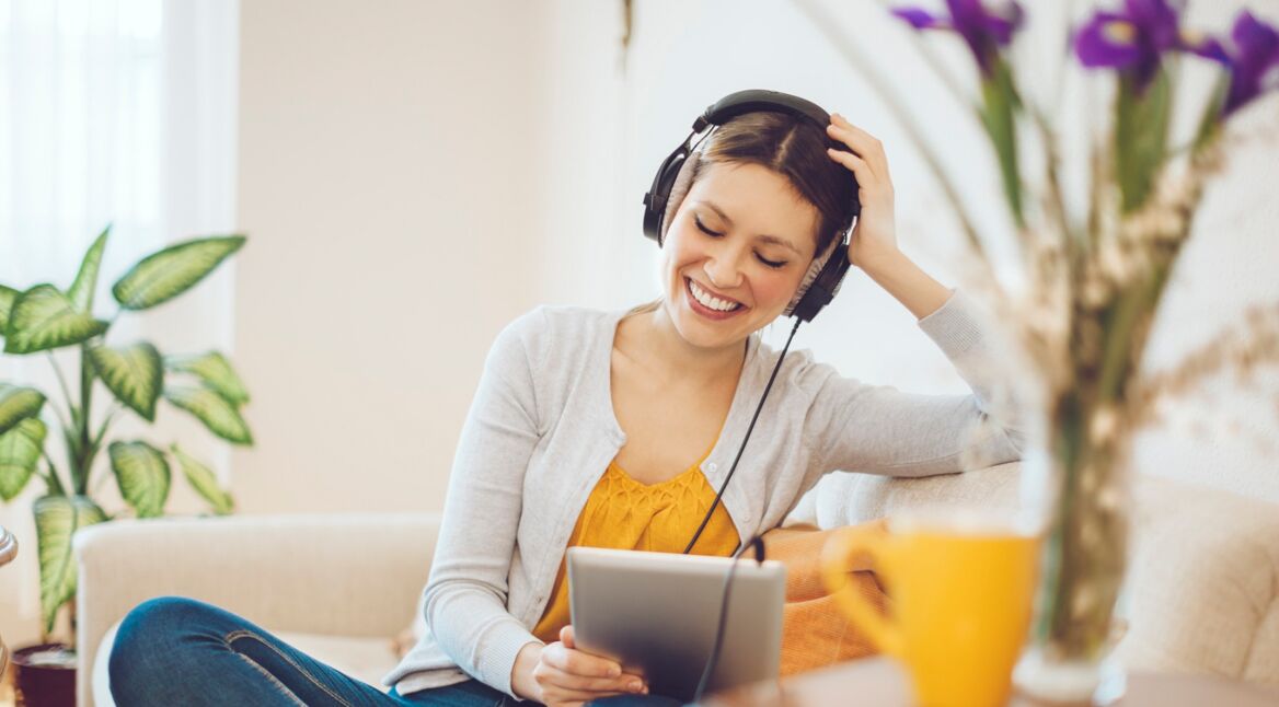 Eine Frau hört „Die Blaue Stunde“ – einen der besten Comedy Podcasts