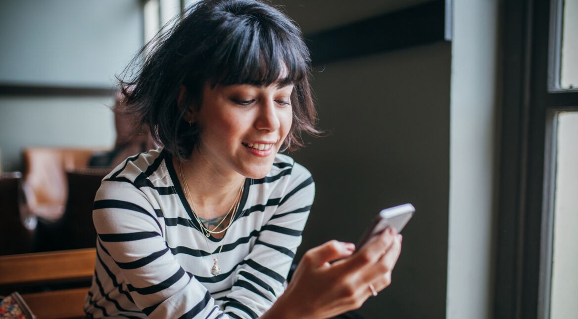 Frau nutzt Telegram auf Handy