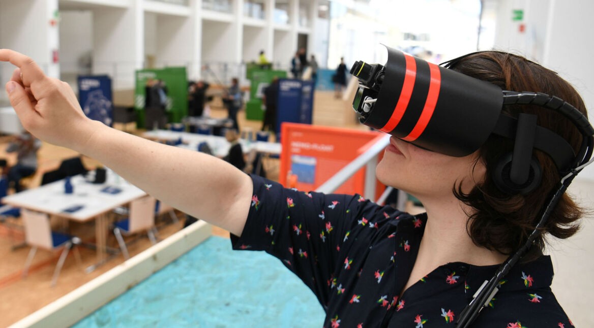 Eine Frau trägt eine VR-Brille und erlebt Inhalte in der virtuellen Realität.