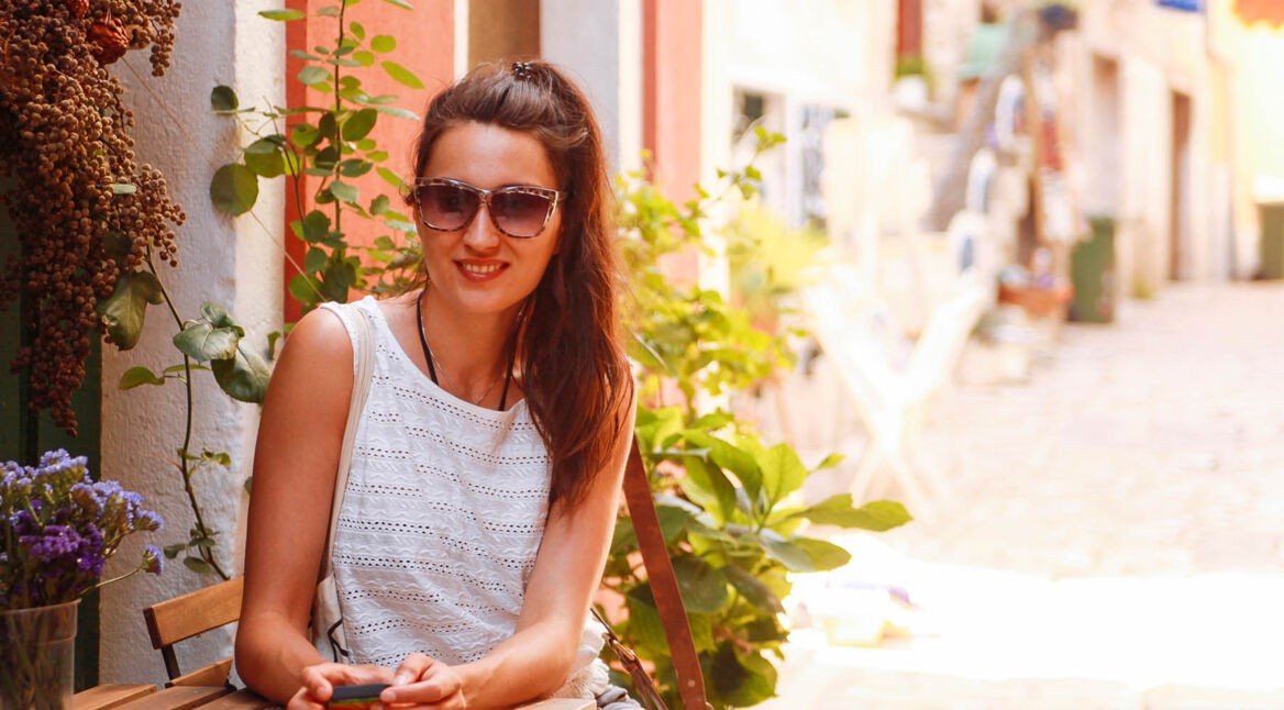 Junge Frau hält ihr Smartphone in der Hand, das einen Passwort-Manager installiert hat.