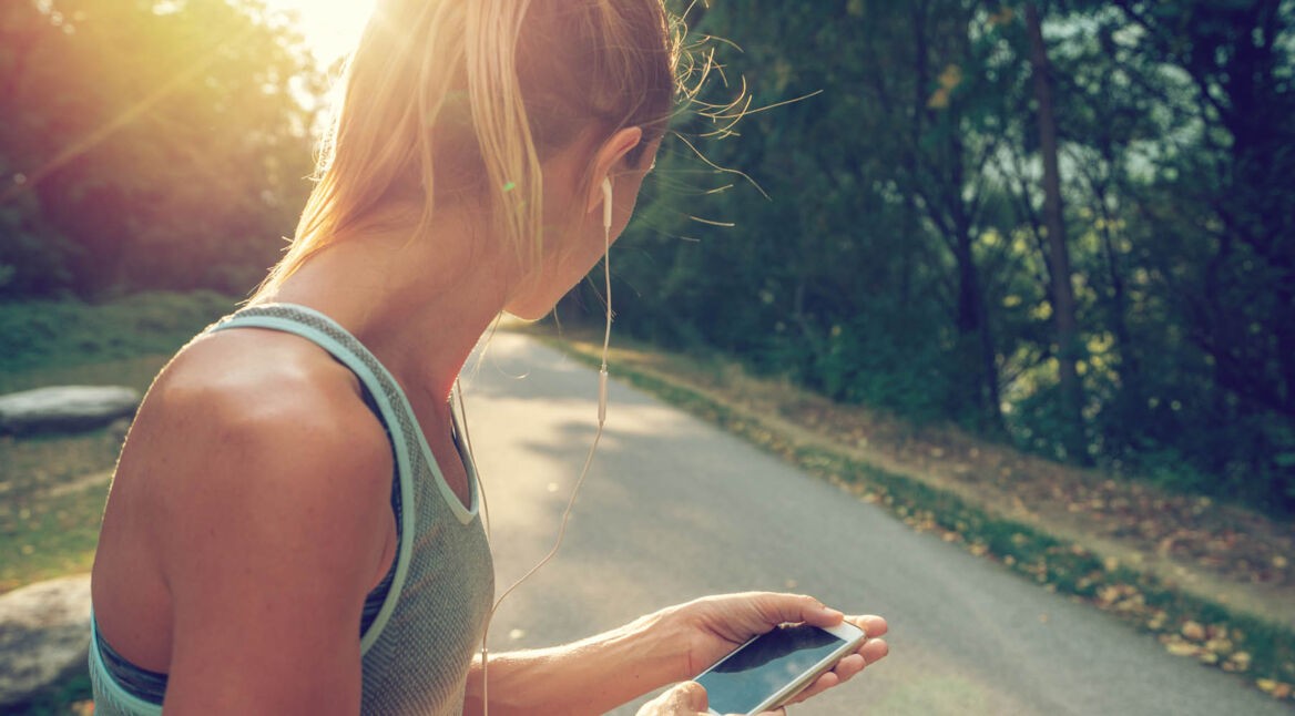 Junge Frau hört über ihre Kopfhörer Musik von Deezer.