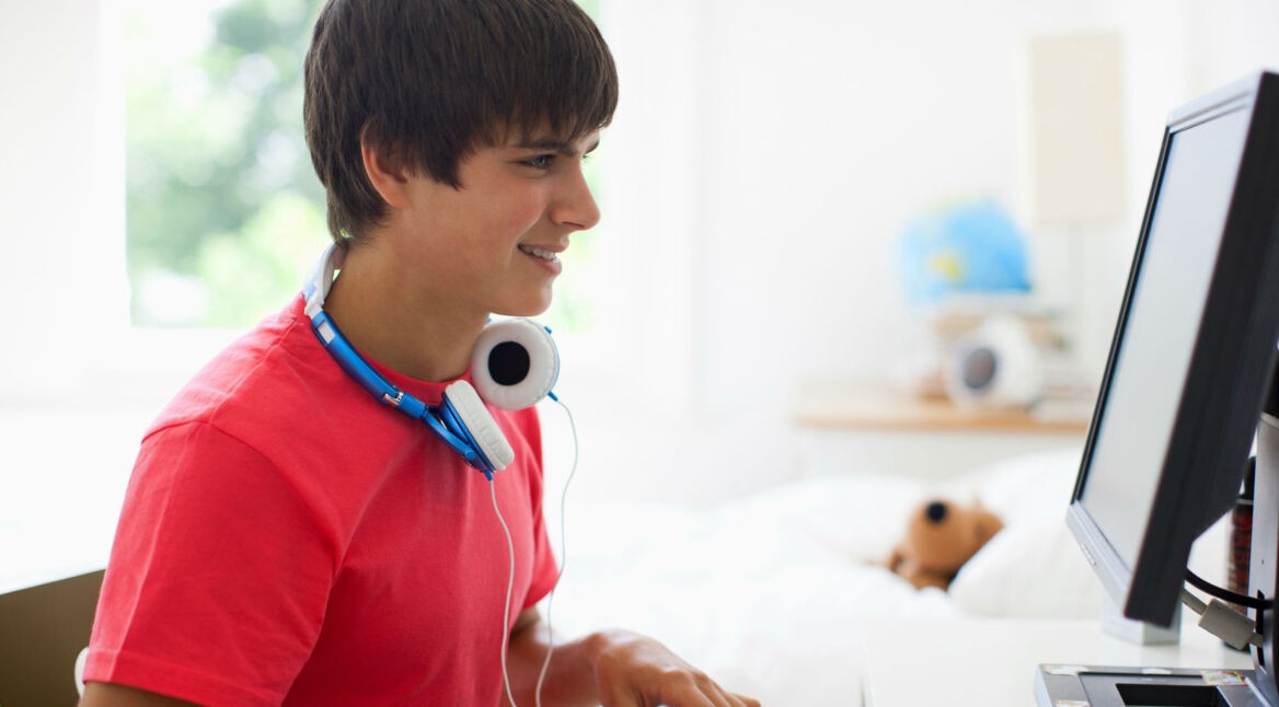 Junger Mann steuert am PC die Windows-Benachrichtigungen.