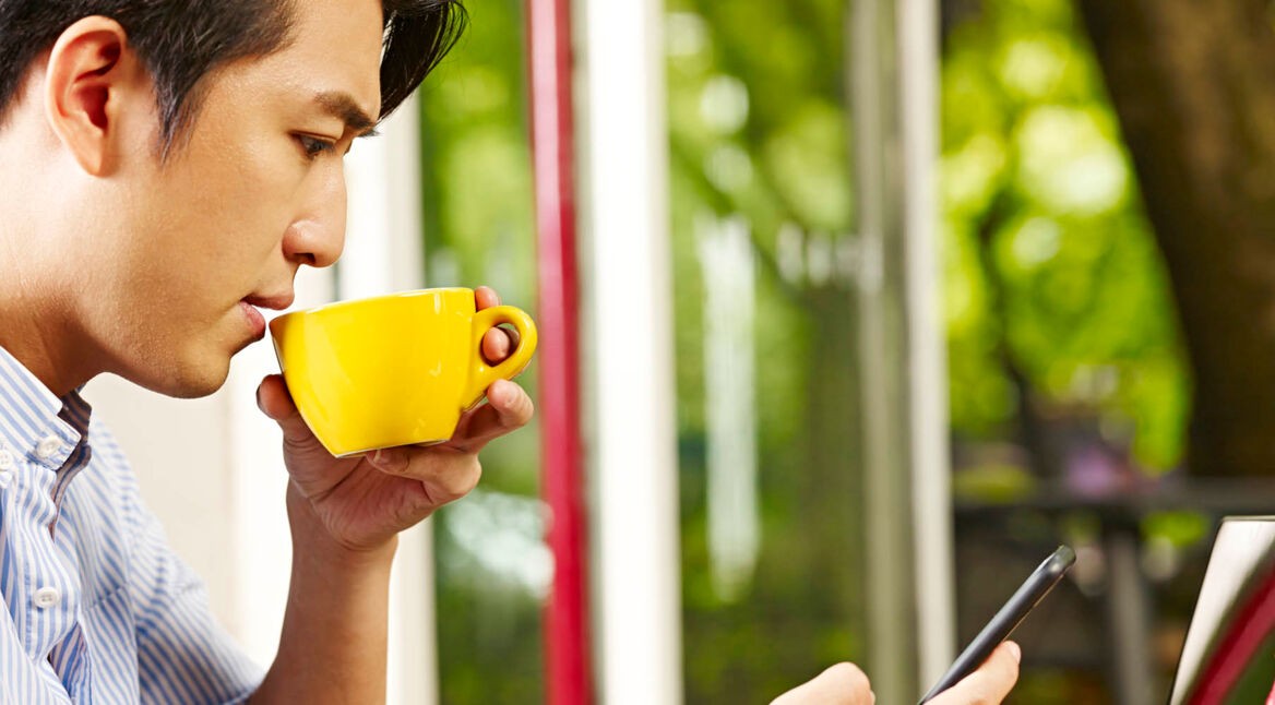 Junger Mann testet am Smartphone Android 10.