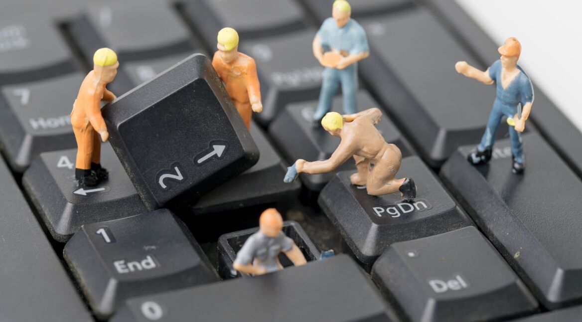 Kleine Männchen reparieren eine defekte Tastatur