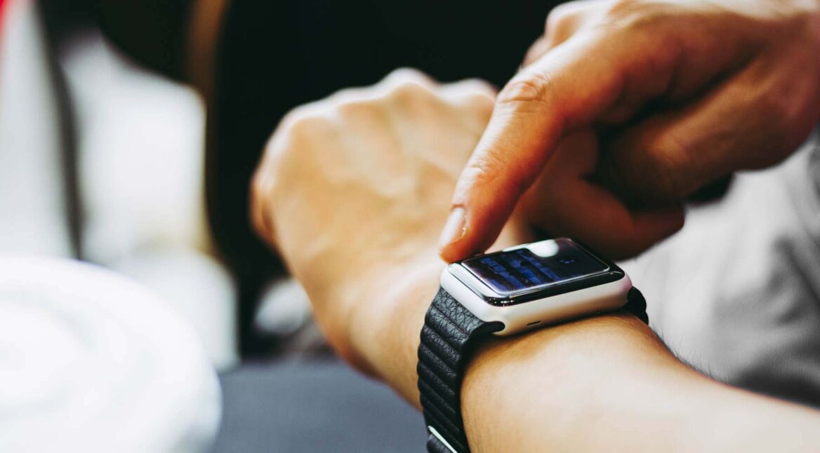 Hand tippt auf das Apple-Watch-Display, um ein Update anzustoßen.