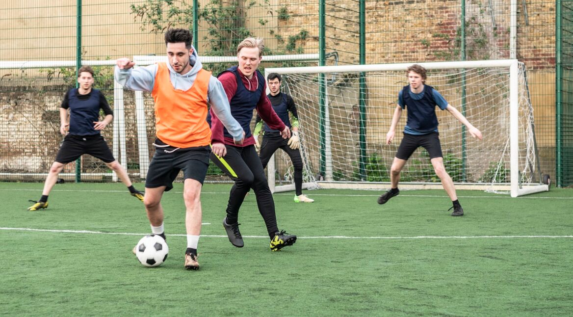 Jungs kicken auf einem Bolzplatz