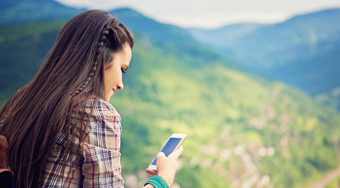 Junge Frau erhöht am iPhone den Farbkontrast des Displays.