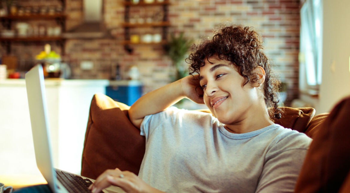 Junge Frau durchsucht am Macbook ihren Library-Ordner.