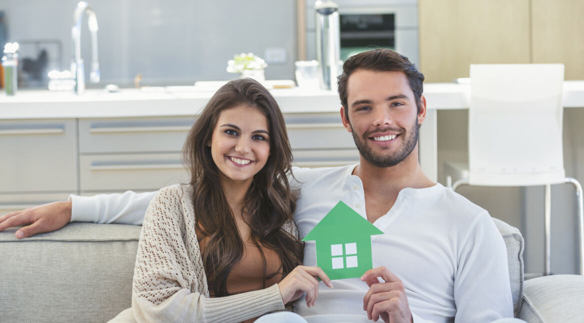 Paar hält kleines Haus in der Hand