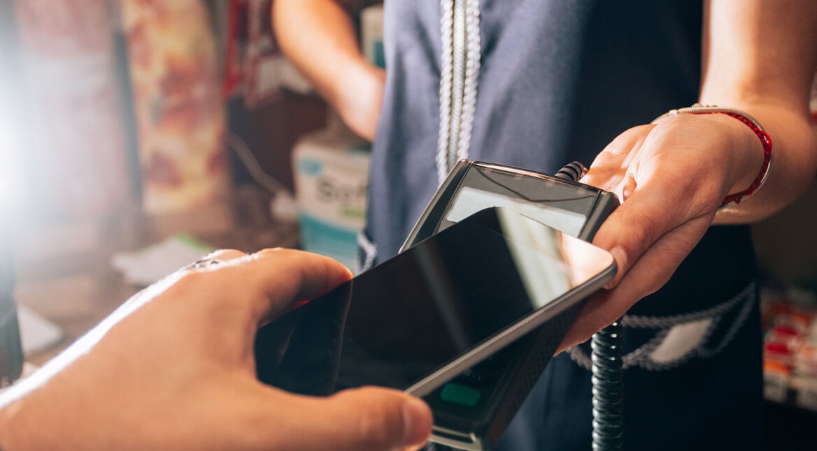 Eine Person bezahlt mit einem Smartphone