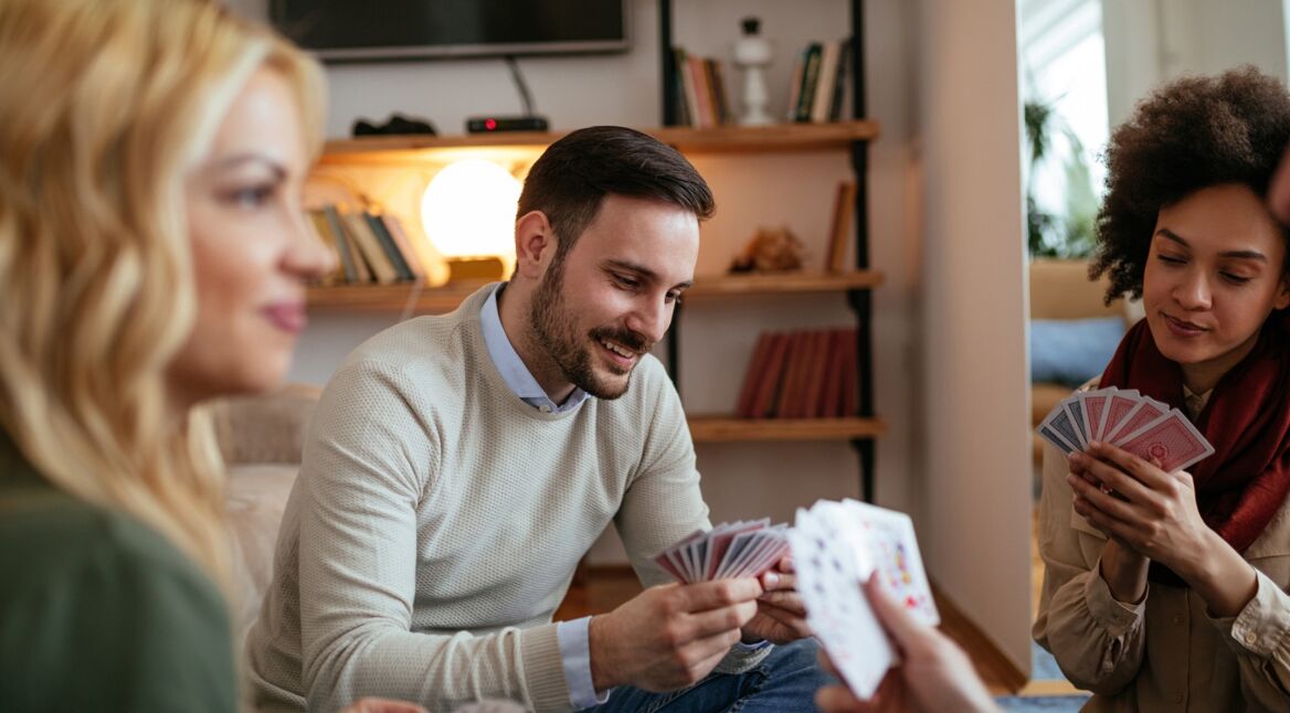 Eine Gruppe junger Menschen spielt eine Runde Doppelkopf.