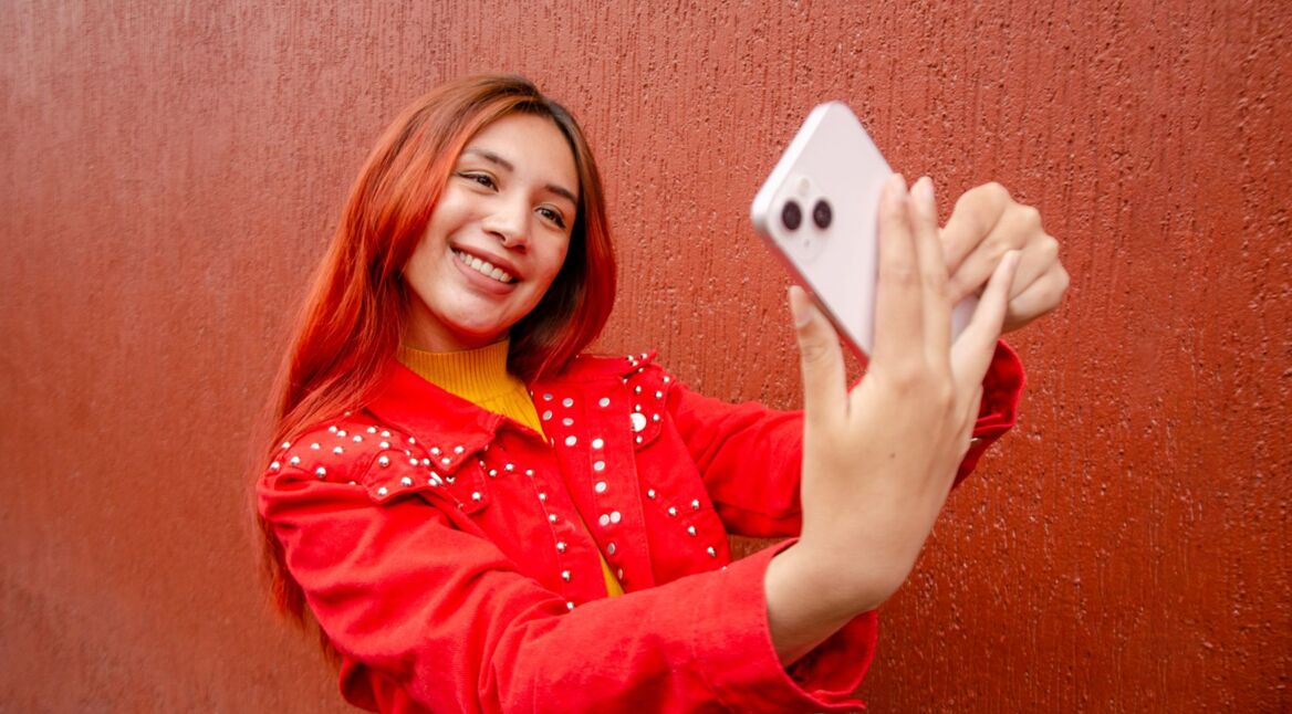 Frau nimmt Selfie von sich mit dem iPhone auf.