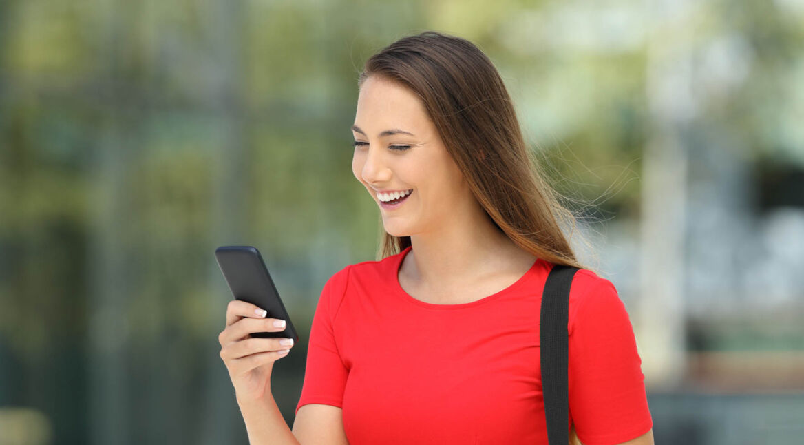 Junge Frau installiert am Smartphone ein Update für Kodi.