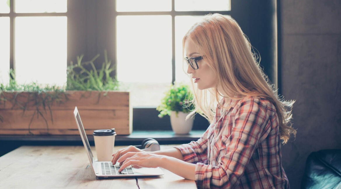 Frau arbeitet am MacBook und optimiert dessen Speicher.