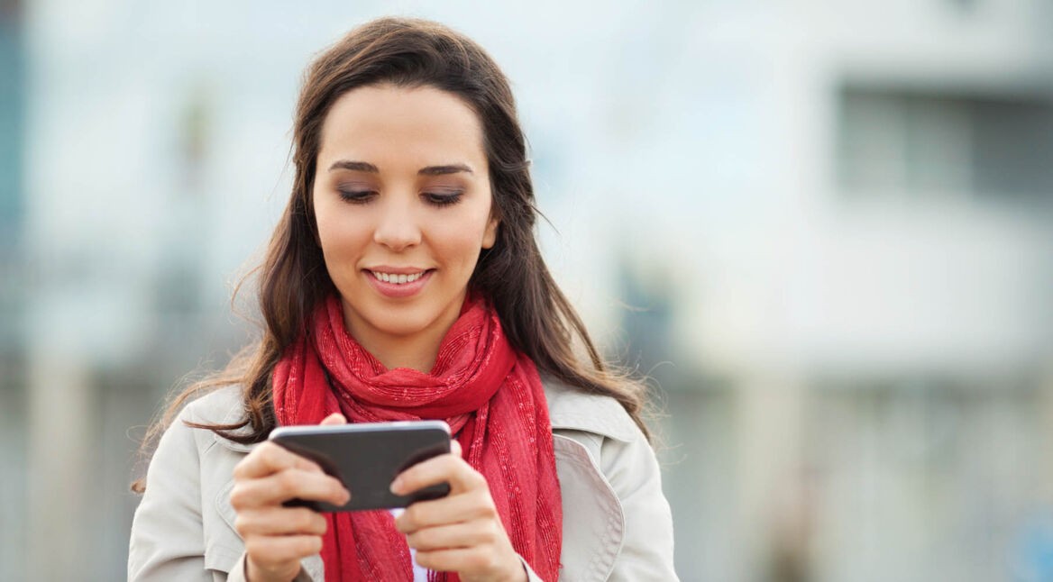 Junge Frau spielt am Smartphone ein von Google Play ausgezeichnetes Indie-Spiel.