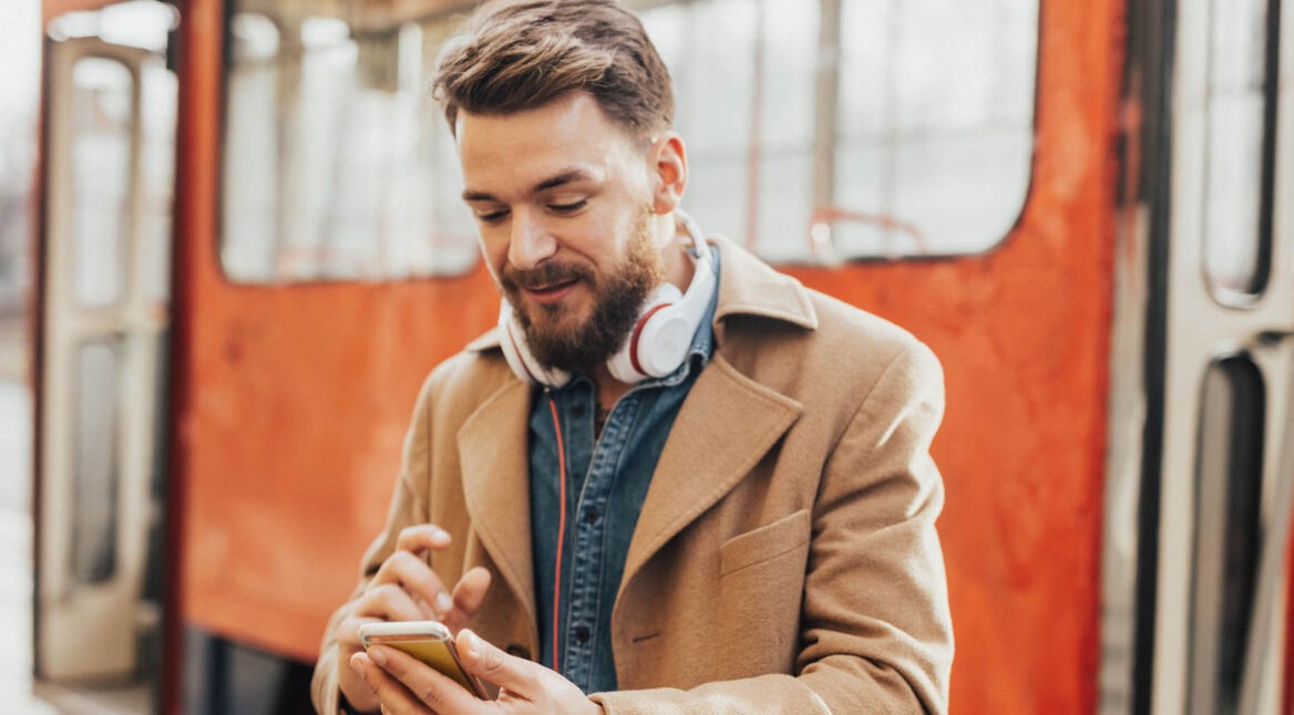 Junger Mann löst Problem mit Spotify am Smartphone.