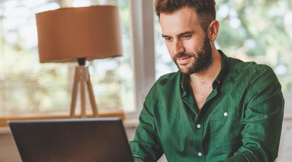 Mann tippt in Microsoft Word am Laptop.