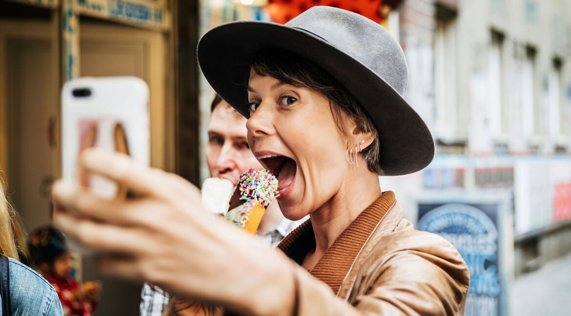 Junge Frau isst Eis und schießt ein Selfie