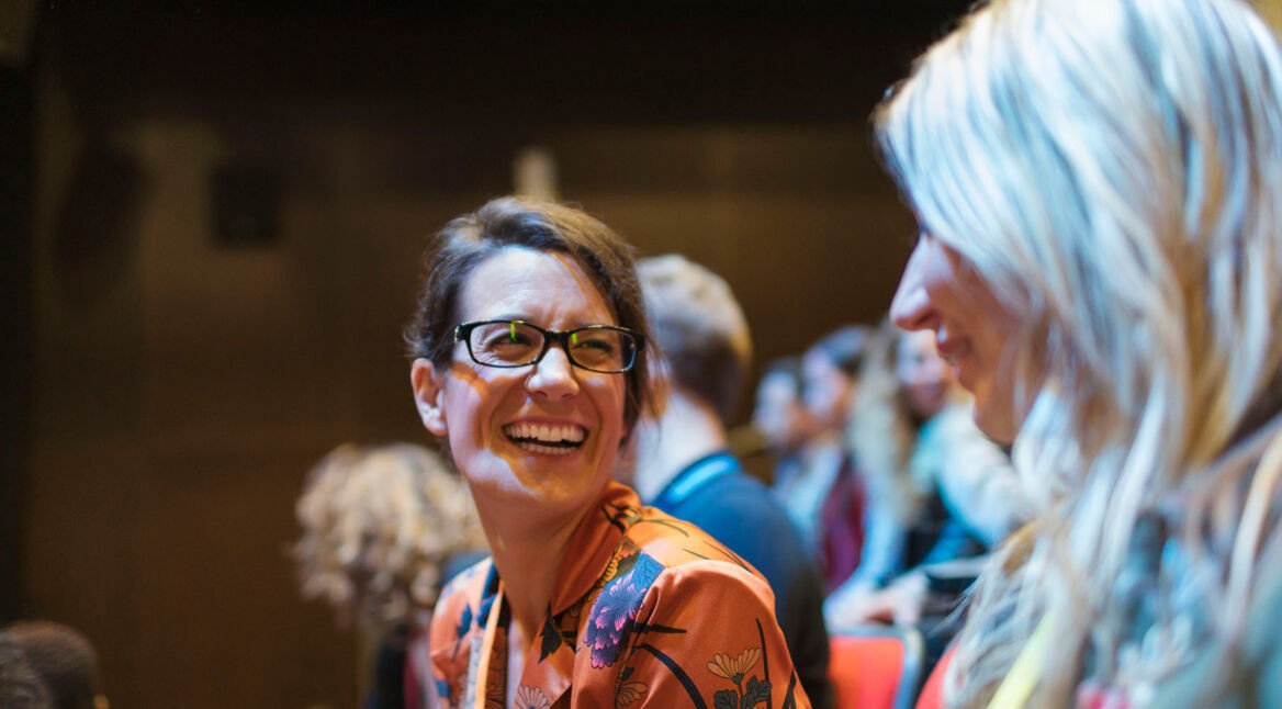 Frau lacht über Stand-up-Comedy-Auftritt.