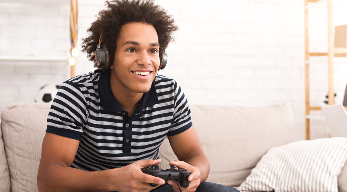 Mann zockt vom Sofa aus PS4