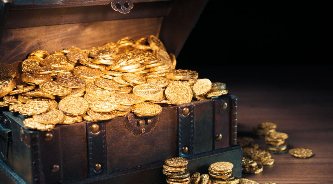 Schatzkiste aus Holz mit Goldmünzen.