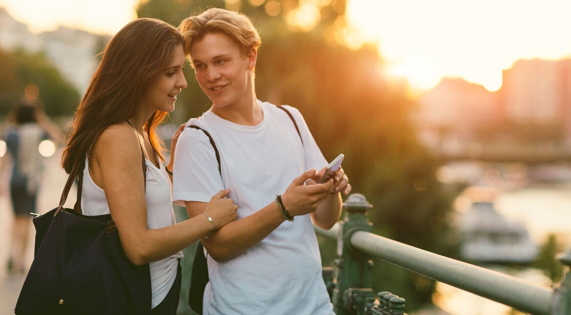 Zwei junge Menschen schauen auf ein Smartphone