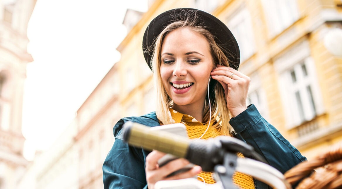 Junge Frau hört via iPhone wieder Musik mit Apple Music.