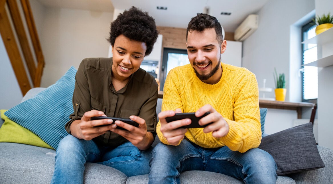 Zwei junge Menschen spielen am Smartphone