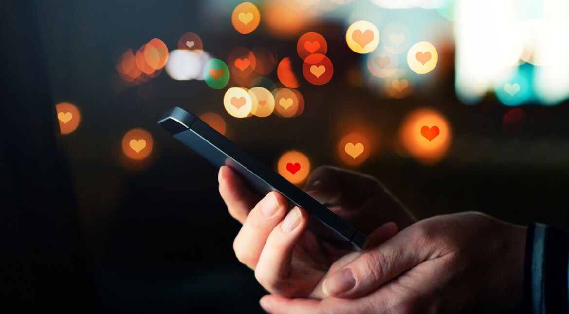 Handy in Händen und Herz-Icons