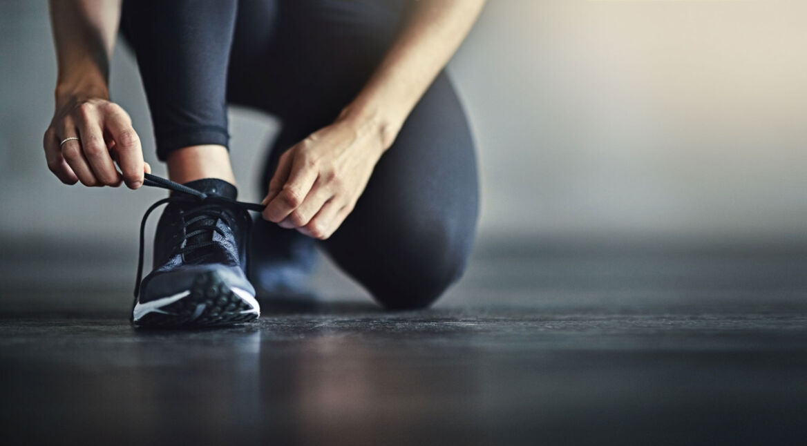 Frau bindet ihren Sportschuh zu - Neue Puma-AR-Sneaker stehen per App in Flammen