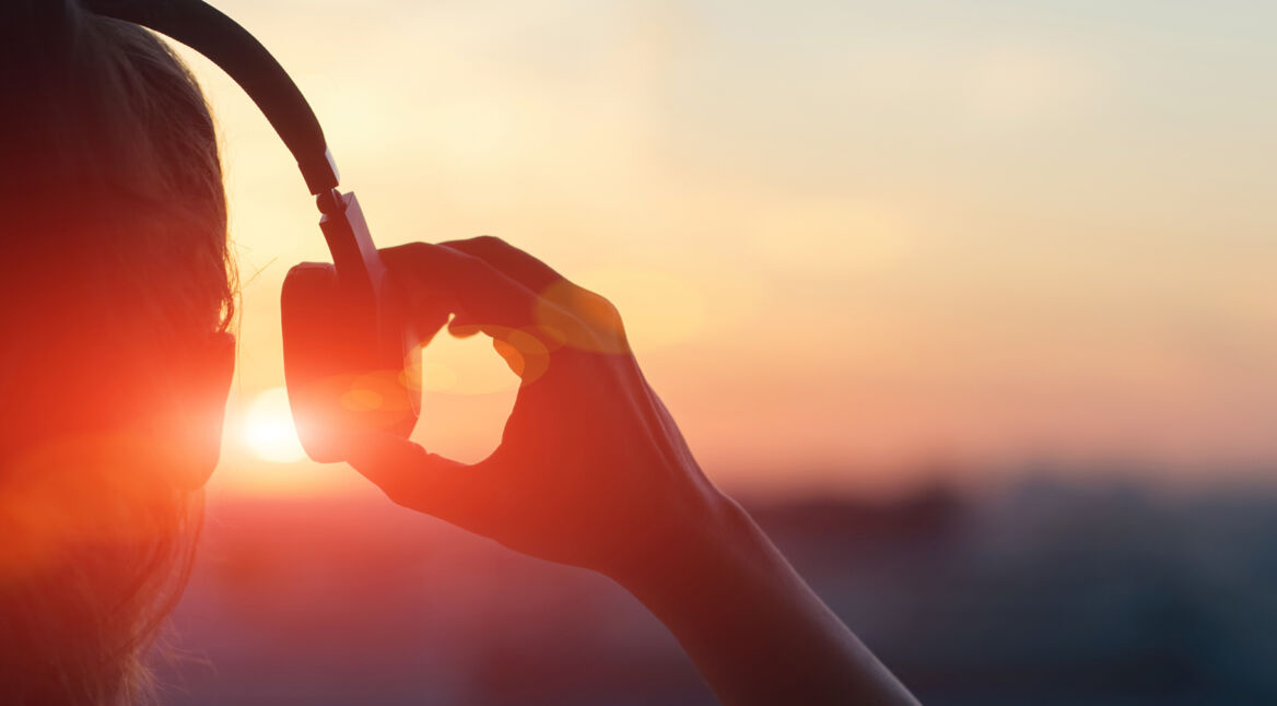 Frau mit Kopfhörern nutzt smarte Musik-App