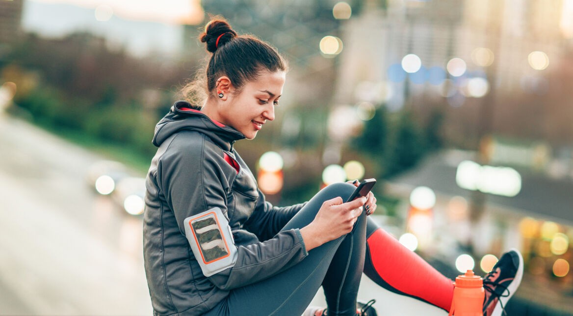Frau mit Sportklamotten und Handy