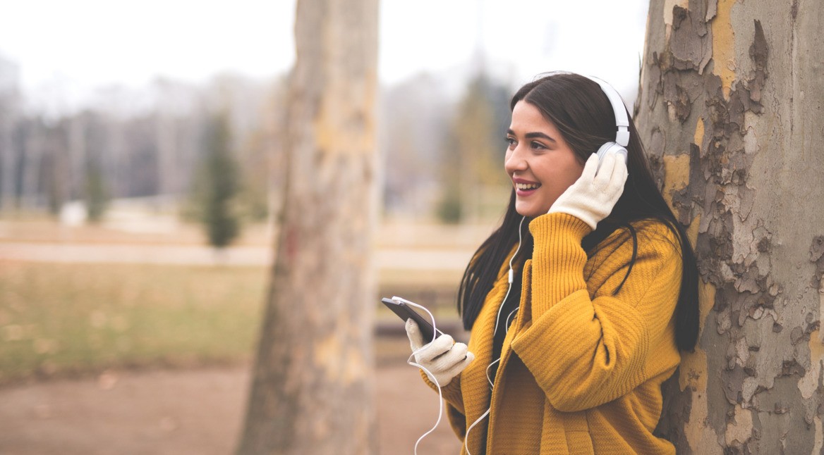 Frau hört via Smartphone einen empfehlenswerten Podcast.