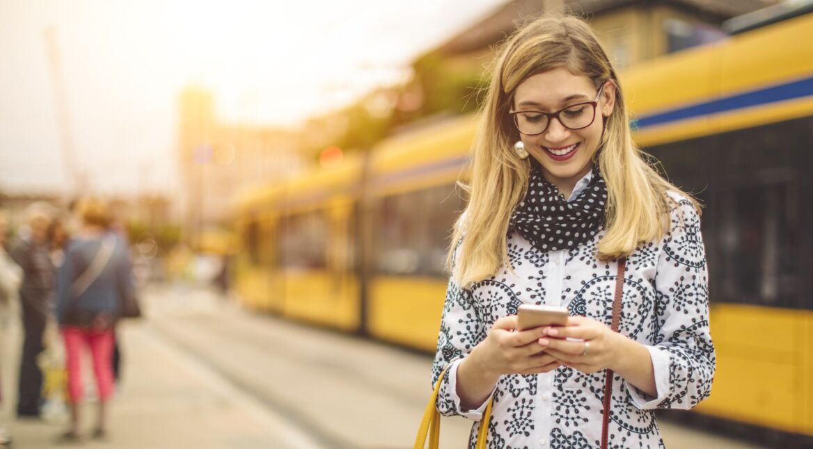 Frau schaltet am iOS-Smartphone einen unbekannten Anrufer stumm.