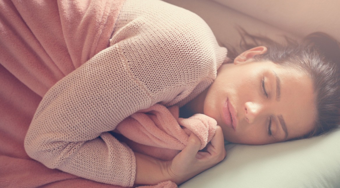 Frau schläft im Bett ein.