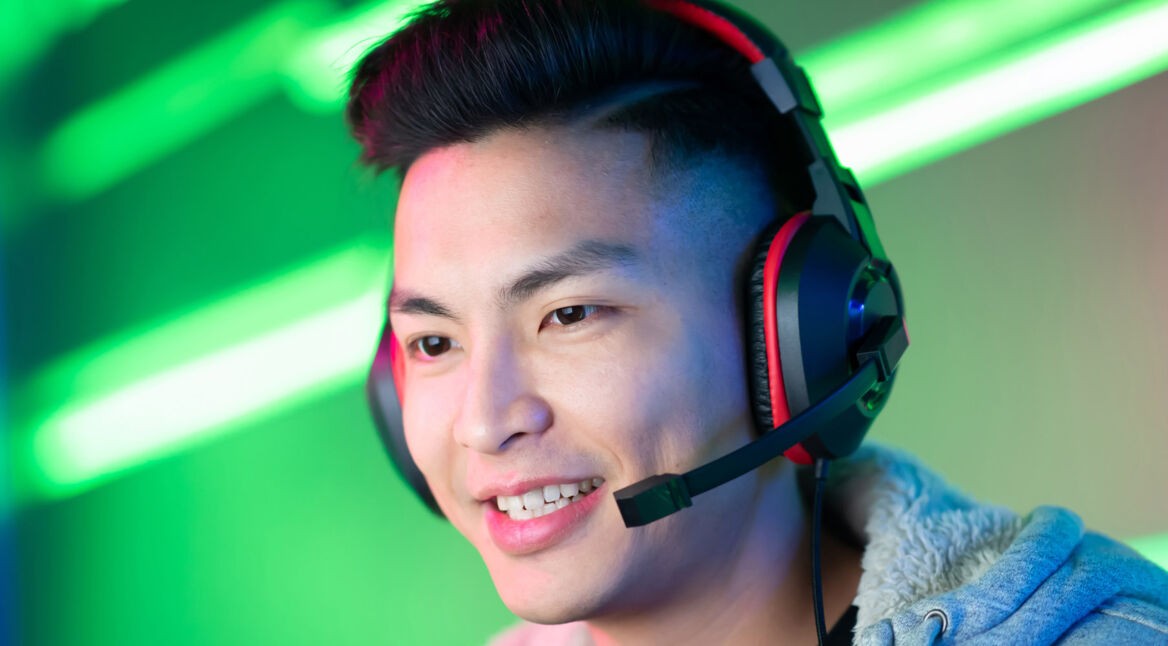 Junger Mann trägt schwarzen Kopfhörer für die Nintendo Switch.