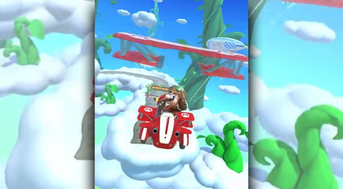 Mario fliegt in Mario Kart Tour mit seinem Kart durch die Luft und zeigt dabei den Daumen hoch