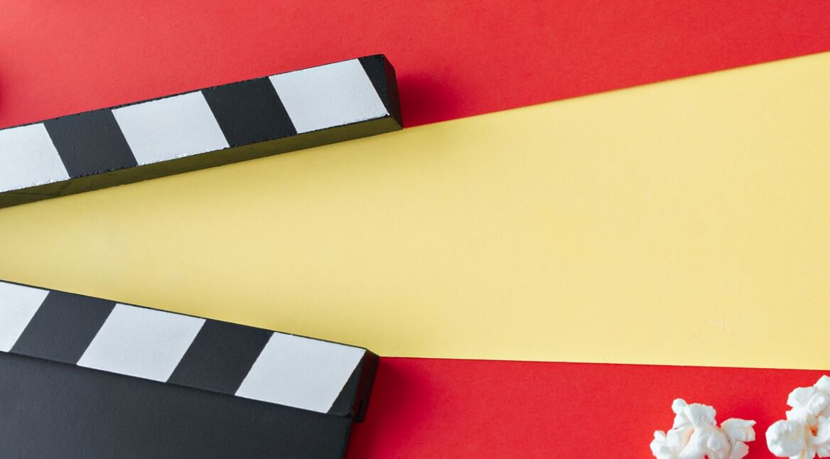 Filmklappe liegt auf rotgelbem Hintergrund.