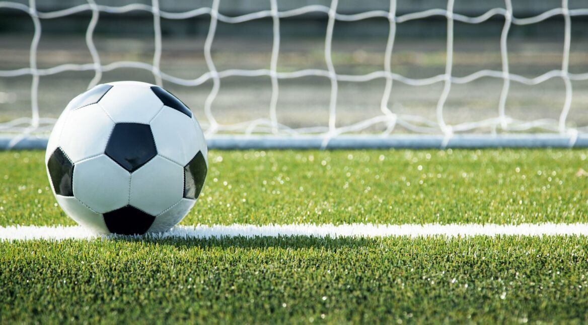 Ein Fußball rollt ins Tor.