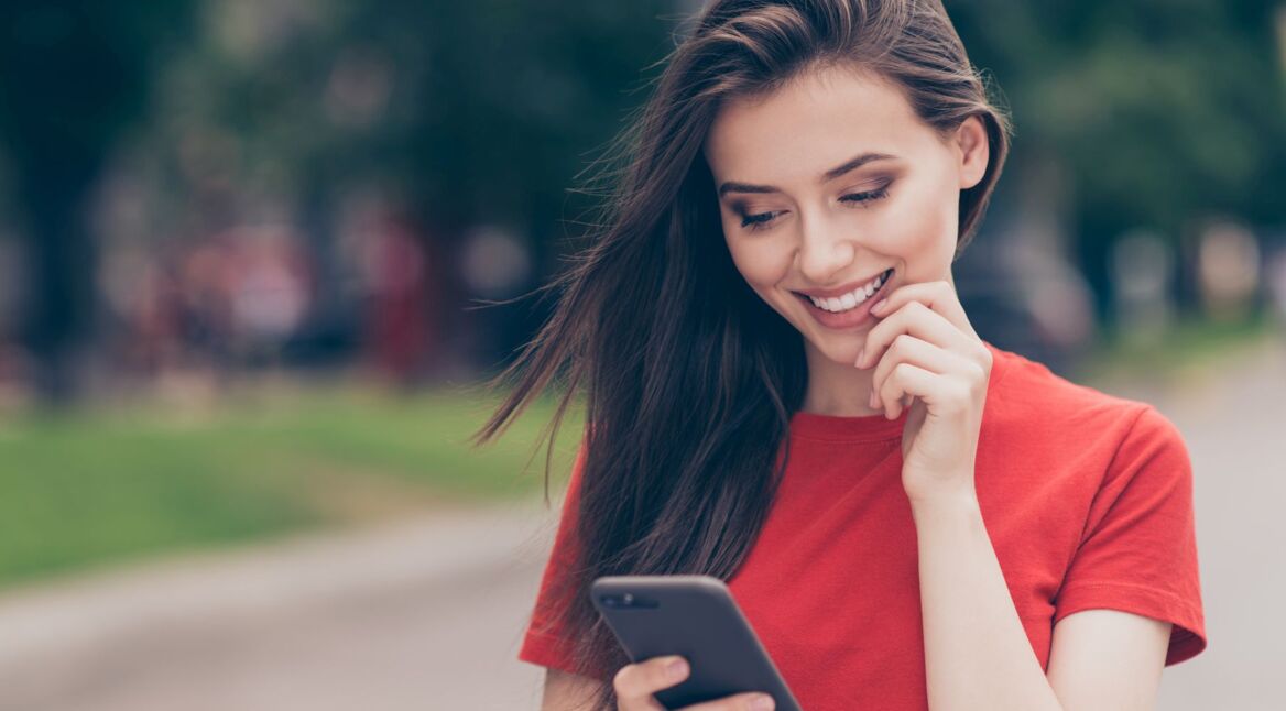 Junge Frau spielt am Smartphone ein neues Apple-Arcade-Spiel.