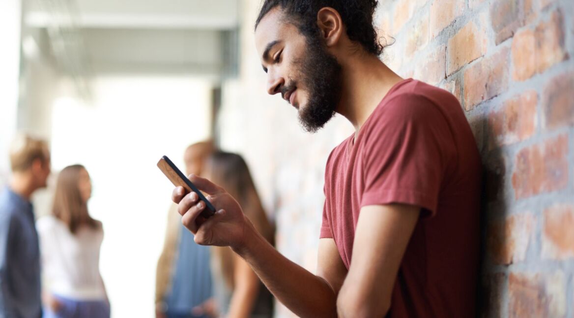 Junger Mann schaltet am Android-Smartphone den Nicht-stören-Modus ein.