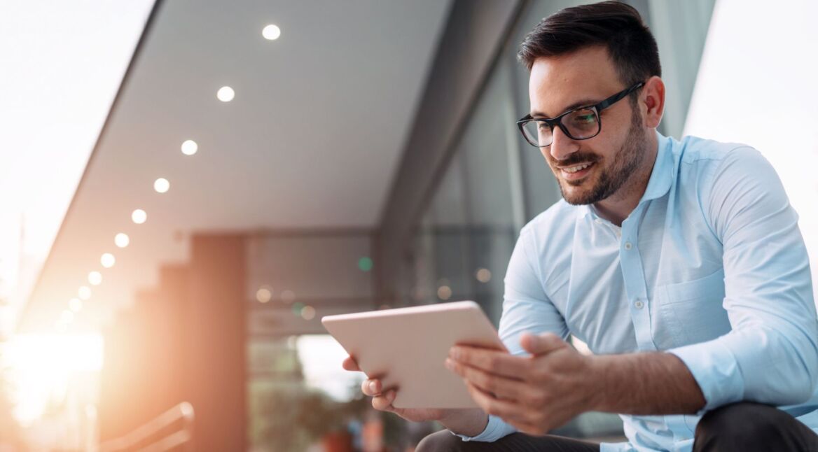 Junger Mann richtet am iPad den Home-Bildschirm ein.