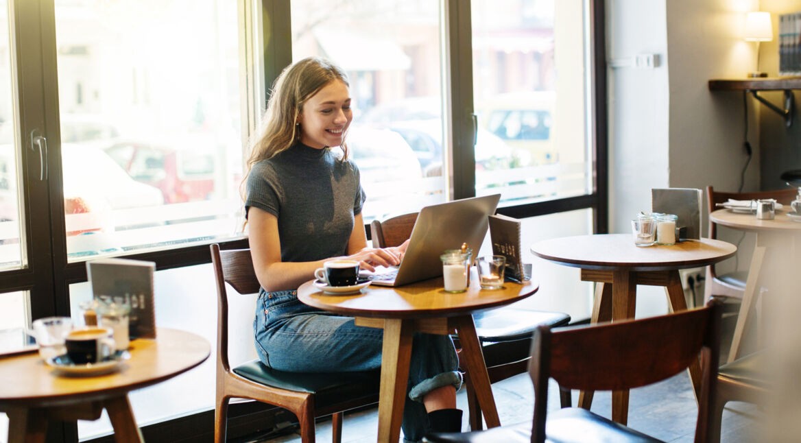 Junge Frau mit Laptop im Cafe
